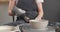 Medium shot of young caucasian female potter in pottery workshop. Woman in apron is drying ceramic blank on rotating