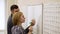 Medium shot of young man helps a girl learn Chinese characters in the office