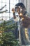 medium vertical shot of an Afro-American man with glasses holding lights in front of a Christmas tree