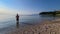 Medveja - A man in swimsuit stands in the shallow water on a stony beach