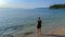 Medveja - A woman in shorts walking on the shallow water on a stony beach of Medveja in Croatia