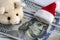 Meet the New Year without financial debts. The Santa`s hat lies on Franklin`s head on hundred dollars, a pink soft toy pig, and