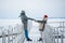 A meeting of a couple in love in winter on a pier on a frozen lake