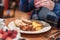 Meeting friends for breakfast, woman adding salt and pepper to omlette