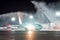 Meeting a new aircraft at a night airport, the tradition of wash spray pouring water from fire trucks.