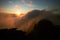 Meeting sunrise in Huangshan mountains. China, early morning. Male silhouette, rising sun and clouds