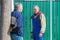 Meeting of two mature neighbors at the gate of a rural house on a sunny day