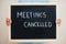 Meetings cancelled. Coronavirus concept. Boy hold inscription on the board