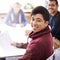 Meetings keep us on the same page. Portrait of a happy young man sitting in a meeting with his colleagues.