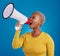 Megaphone, shouting and angry black woman in studio for message, broadcast or vote on blue background. Speaker