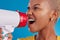 Megaphone, shouting and face of black woman in studio for message, broadcast or vote on blue background. Speaker