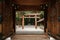 Meiji Jingu Shrine wooden Torii seen through old gate entrance - Tokyo