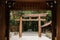 Meiji Jingu Shrine wooden Torii seen through old gate entrance - Tokyo