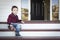 Melancholy Mixed Race Boy Sitting on Front Porch Steps