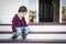 Melancholy Mixed Race Boy Sitting on Front Porch Steps