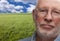 Melancholy Senior Man with Grass Field Behind