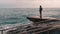 Melancholy young boy standing at pier. Lonely boy looking at rainy stormy sea. Pessimistic man at sea marina. Young boy in dark we