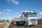 Melbourne, VIC/Australia-Sept 21st 2020: A large truck passing a traffic controller with a stop/slow bat near a site of roadworks