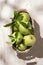 Mele Granny Smith in cestino. Frutta fresca verde su fondo bianco rustico