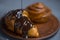 Melted black or milk chocolate pours onto a croissant or cinnamon roll