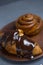 Melted black or milk chocolate pours onto a croissant or cinnamon roll