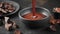 Melted dark chocolate is poured into a bowl. Confectionery home concept.