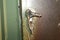 Melted door handle after a house or apartment fire. Green door with melted door handle and rusty lock