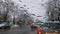 Melted snow and rain drops on the windshield of a car. Blurred outdoor view, winter season sleet as seen out of vehicle window