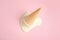 Melted vanilla ice cream in wafer cone on pink background