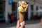 Melting delicious ice cream in waffle cone gelato pistachio salty caramel holding female hand