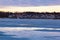 Melting frozen lake with puddles of water within the frozen lake surface. Dramatic sky with reflections in the frozen lake