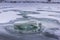 Melting ice in frozen fish pond, aerated in winter