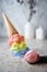 Melting rainbow ice cream waffle cone and scoop. Close up