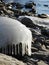 Melting wave ice covering shore rock