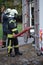 A member of the fire brigade holds a water supply hose