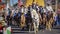 Members of the Scottsdale Charros Foundation civic charity and club mounted on horses and carrying flags in the Scottsdale