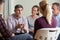 Members Of Support Group Sitting In Chairs Having Meeting