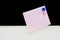 Memo pink paper with blue magnet on black and white background