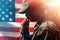 Memorial day, veterans day. Portrait of Soldiers a woman holds a rosary and prays, raising them to her mouth. American flag on the