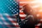 Memorial day, veterans day. A young woman holds a rosary in her hands and prays. American flag on the background. Copy space.