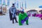 Men animators wearing costumes of Batman and Mister Hide entertaining people with frightful show in outdoor apres ski cafe of Gork