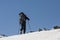 Men ascending profiled on a blue sky during ski touring