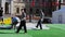 Men building stage on street. Workers carry heavy sack , lay on green carpet