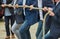 Men with business clothing and formal jackets pulling together on a thick rope, concept photo of the expression