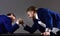 Men or businessmen with tense faces compete in armwrestling