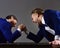 Men or businessmen with tense faces compete in armwrestling