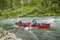 Men canoeing on raging river rapids in wild Alaska