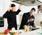 Men chefs in black uniform having conflict on kitchen