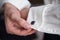 Men closing a gem stone button on his white shirt - close up