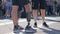 Men with disability in shorts with artificial leg in comfortable sports shoes is standing outside on background of crowd